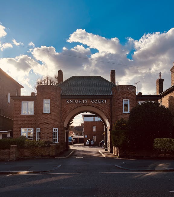 A brick archway labeled 'Knights Court' serves as the entrance to a residential complex located in Elephant and Castle near New Kent Road. The arch is flanked by two small, rounded tower-like structur
